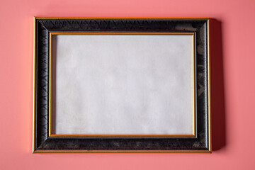Black photo frame on a pink background.