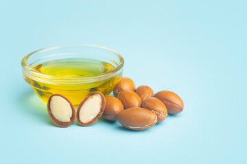 Argan seeds and oil on a dark blue isolated background. Argan oil based cosmetics concept.
