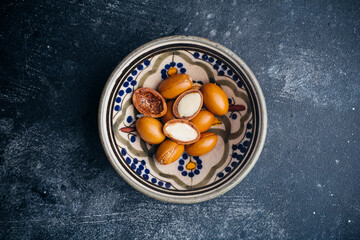 Argan seeds  on a dark background. Argan oil based cosmetics concept.