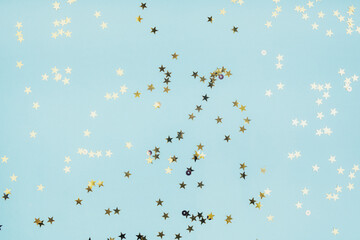 Confetti stars on blue background. Festive holiday background. Celebration concept. Top view, flat lay.
