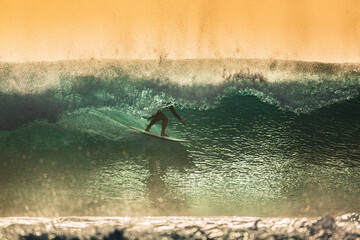 A man riding a barrel wave on a surfboard in the ocean in Indonesia