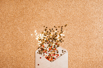 Gift envelope with confetti stars on suberic background. Festive holiday background. Celebration concept. Top view, flat lay.