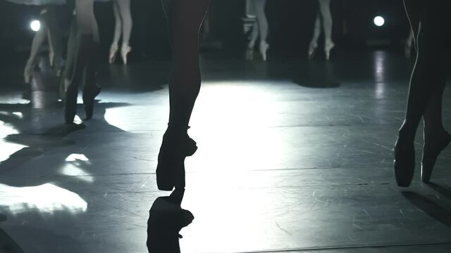 closeup of ballerinas legs dancing graceful classic performance on stage Spbd. feet in spotlight silhouette. tutu for swan lake. slow motion. professional concert of ballet
