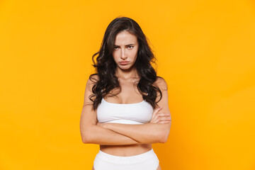 Image of displeased woman in swimsuit posing on camera with arms crossed