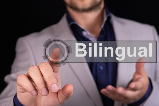 Businessman On A Black Background Pressing An Bilingual Concept Button.