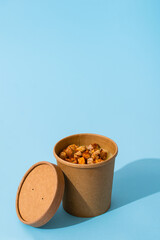 Potato cream soup with croutons in craft containers on a blue background. Vegetable soup to go, takeaway food