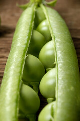 Close up of freshly picked peas on a wooden table.