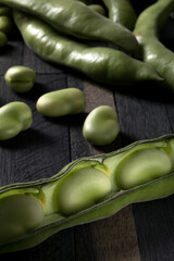 Fresh picked broad beans on a wooden table.