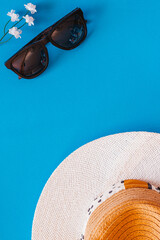 Flat lay of objects related to summer and spring against a blue background