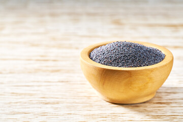 poppy seeds  in a wooden bowl  on a rustic background, selective focus.