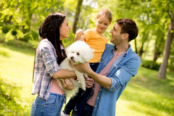 Happy family with cute bichon dog in the park