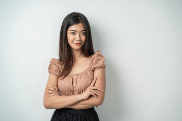 Fototapeta premium beautiful girl with long hair standing while crossing her arms with an isolated background
