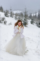 Beautiful bride on a background of a snowy forest. Snowing.