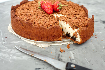 Chocolate cake is decorated with strawberry berries. Homemade cake. Pie on a grey background