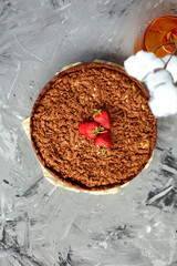 Chocolate cake is decorated with strawberry berries. Homemade cake. Pie on a grey background