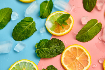 Fototapeta na wymiar Composition with cut citrus fruits on color background. Creative summer background composition with lemon slices, leaves mint and ice cubes. Minimal top down lemonade drink concept.Top view