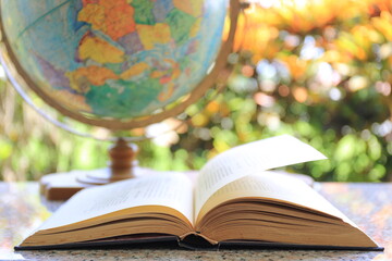 A close up of a book opened on a garden table Natural color light as a background selective focus and shallow depth of field