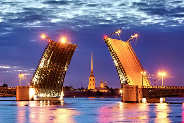 Fototapeta na wymiar A famous view of an open drawbridge in Saint Petersburg during white nights. Palace Bridge and Peter and Paul Fortress. Concept of travelling to Russia. Tourist destination. Night illumination 
