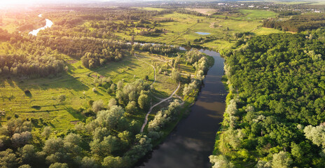 Fototapeta na wymiar Evening aerial view on river bend with sunlight on horizon.