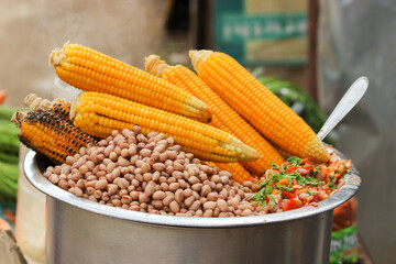 Boiled Sweet corns and peanuts laced with hot chili and lemon juice sold  at a street food corner in Mysuru city / India. 