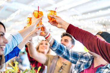 People toasting spritz drink at fashion cocktail bar restaurant - Lifestyle concept with young...