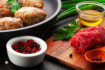 cutlets on pan, forcemeat and spices on board over old rustic background