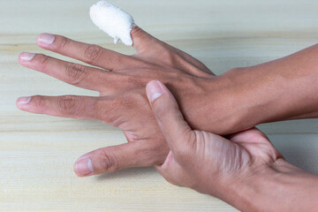 hand of a person who has wrinkles and has a pinky incision