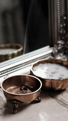 Milk and blue flowers in a bronze bowl.