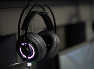 Obraz na płótnie Canvas Professional gaming headphones with bright side led lights hanging off the monitor.