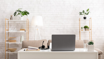 Work room at home. Laptop and headphones on table in interior