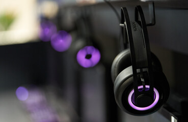 Fototapeta na wymiar Professional gaming headphones with bright side led lights hanging off the monitor.