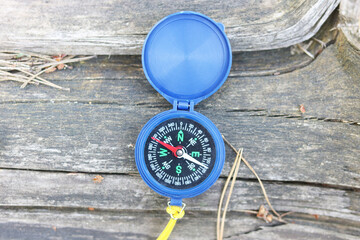 round compass on natural background as symbol of tourism, travel and outdoor activities