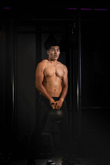 Fototapeta na wymiar Handsome man holding ball with in hands and swing,doing exercise for buit muscle,fit and firm body