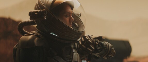 Caucasian female astronaunt checking hud on her suit while exploring planet surface, Mars colonization concept © supamotion