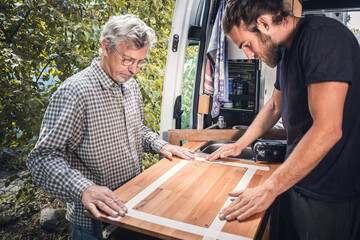 Men preparing wooden countertop for cutting