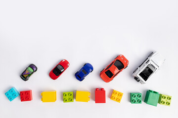 toys constuctor and cars, top view on white background, place for text