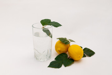 water in a glass with lemons on a white background, lemon water, a glass of water in the morning, healthy lifestyle, place for text