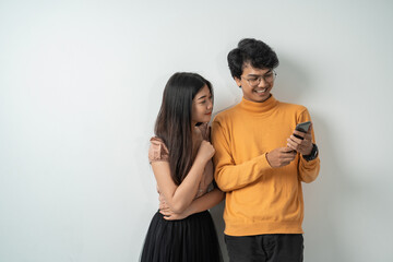 Asian young couples chatting while standing on their smart phones together with isolated backgrounds