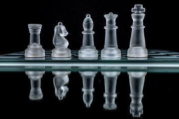 glass chess pieces on black background
