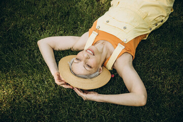 Elderly woman dressed in yellow is having fun in the park
