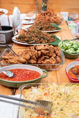 fucusing on the pile of Thai fried fish paste meat balls in glass triangle dish and the others Thai food beside and around it. All are stand by for lunch.