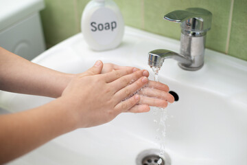 Small girl washing hands with antibacterial soap