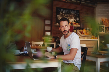 handsome man reading text message during work on net-book in comfortable coffee shop