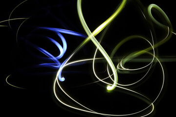 Abstract Blue and Yellow light painting photography, long exposure photo of fairy lights of two particles in a loop against a black background. Neon light painting. Energy concept.