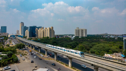 Aerial shot of Rapid metro tracks in urban areas of Delhi NCR, Gurgaon, Noida with metro running on...
