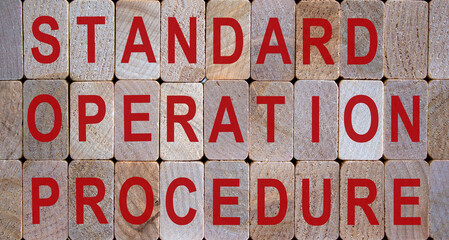 Wooden blocks form the words 'standard, operation, procedure'. Beautiful wooden background.