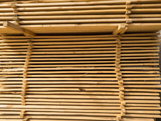 A large pile of boards sawn from trees on a sawmill for the procurement of building materials for construction. Construction industry.