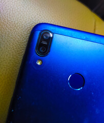 blue colour dual rear camera smartphone with LED flash and finger print sensor. selective focus on subjects and space for text