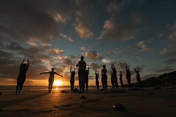 People doing yoga sunset in front of a sunset in Bali