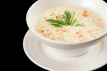 Cauliflower soup. White cream soup with croutons, paprika, dill.Black background